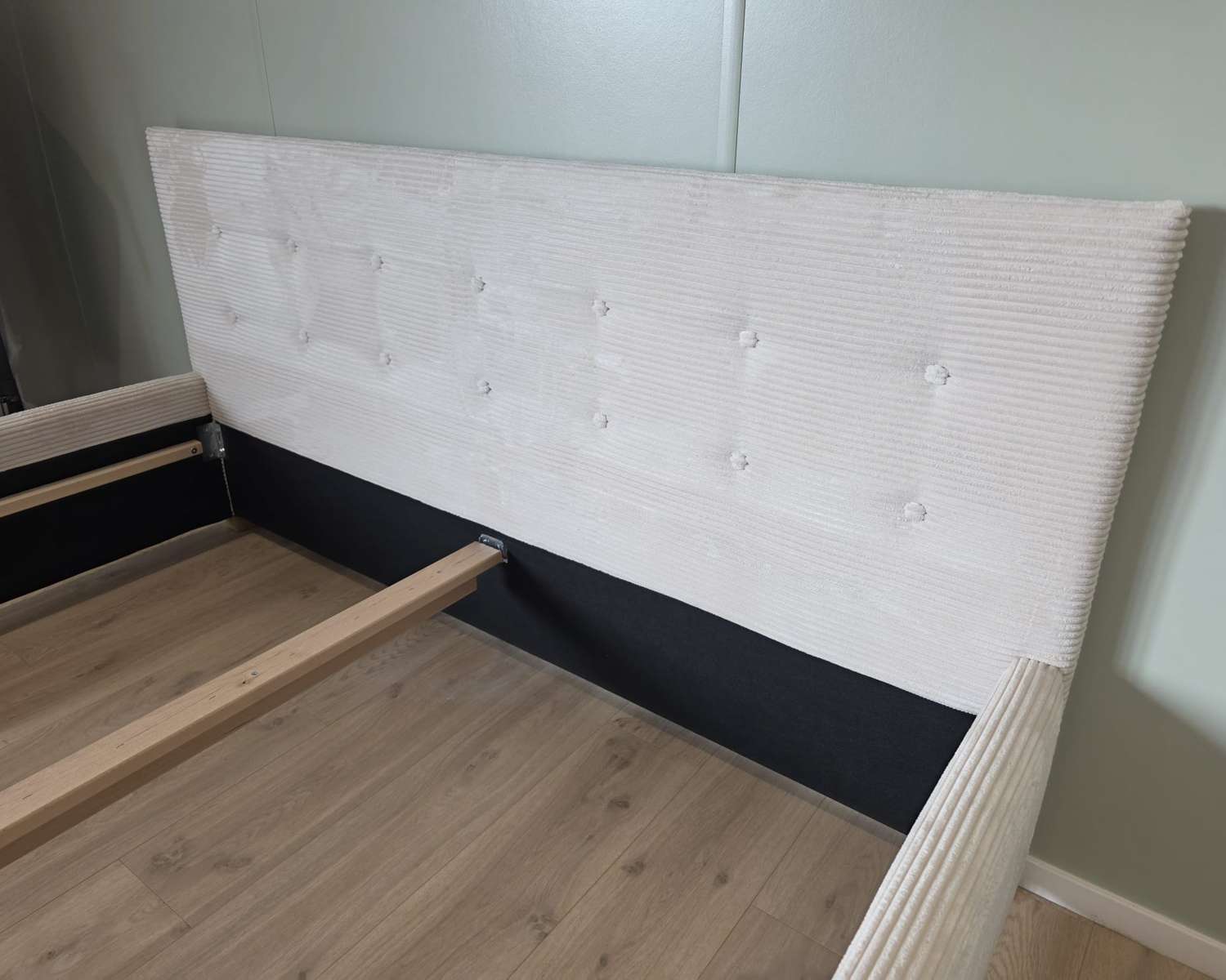 Detail hoofdbord gestoffeerd bed