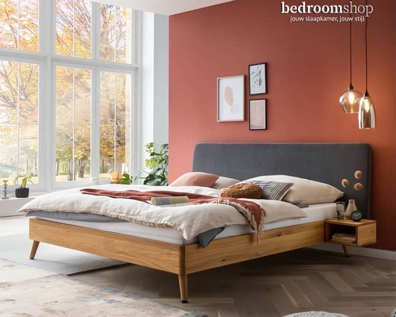 Houten bed met stoffen hoofdbord