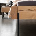 Detail grenen houten bed met metalen beugel