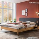 Houten bed met stoffen hoofdbord